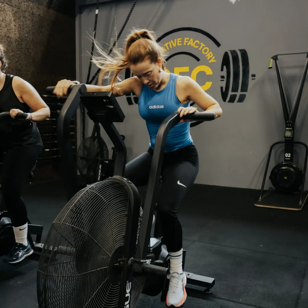 Atleta na air bike em frente ao logótipo Creative Factory CrossFit