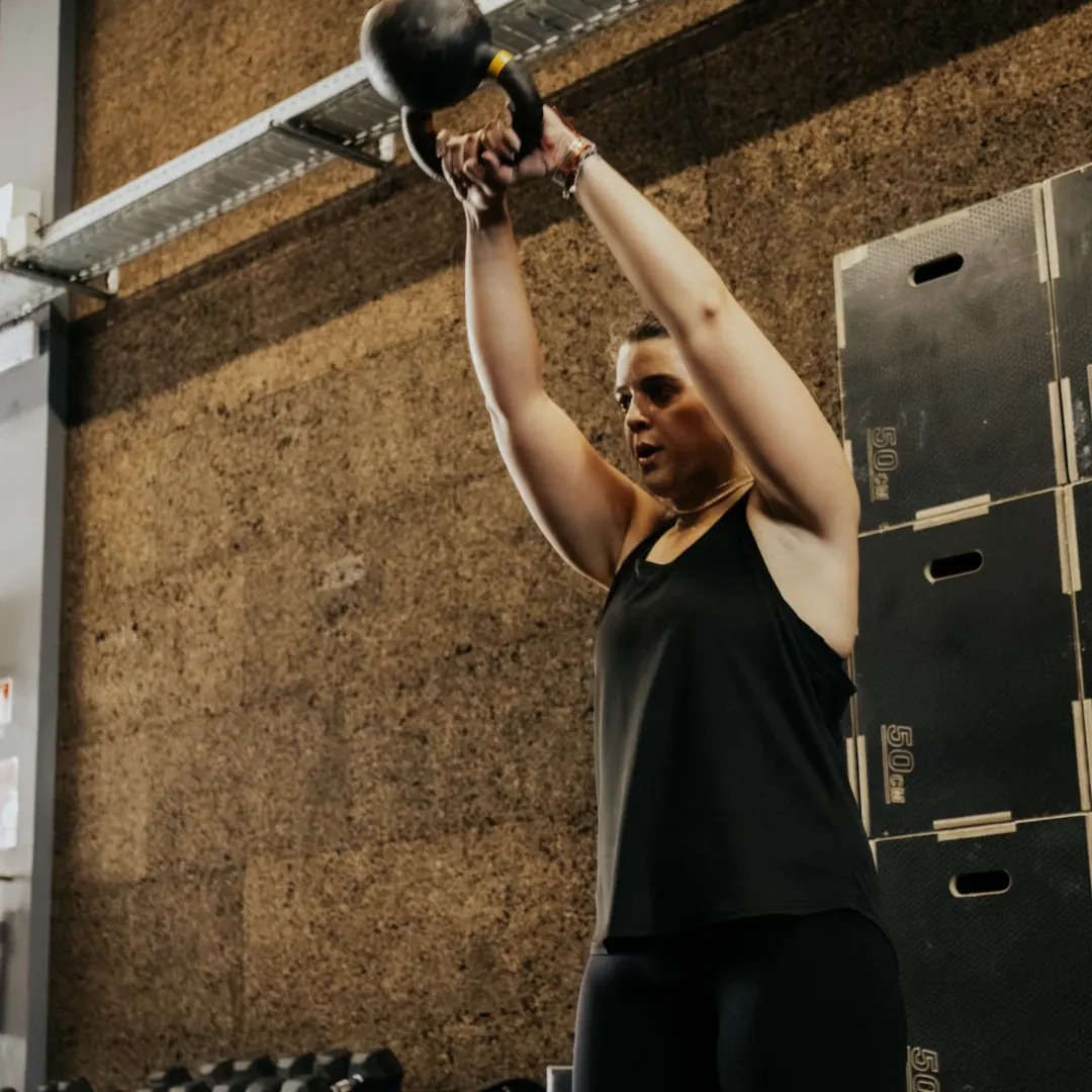Atleta a fazer swing com kettlebell junto às caixas de salto